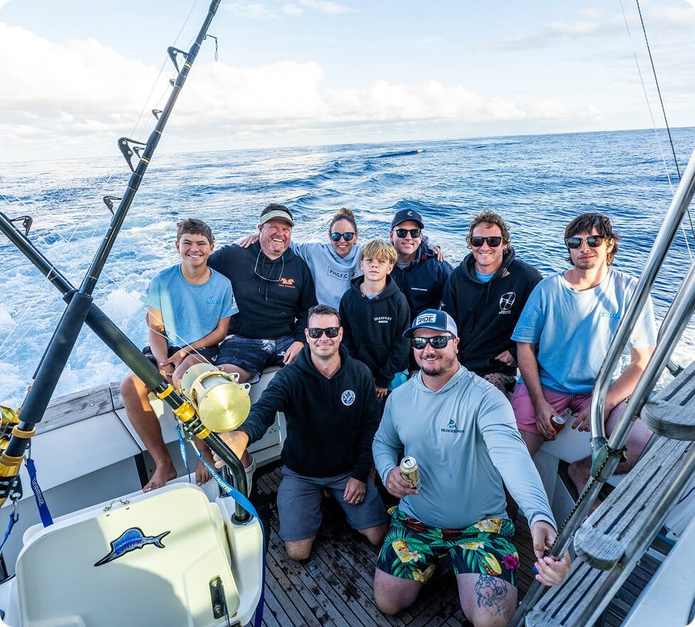 Group of friends smiling on a fishing trip at sea.